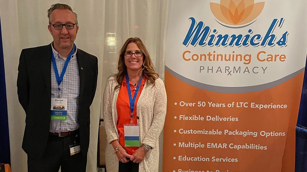 Amy and Deron at community event with Minnich's banner